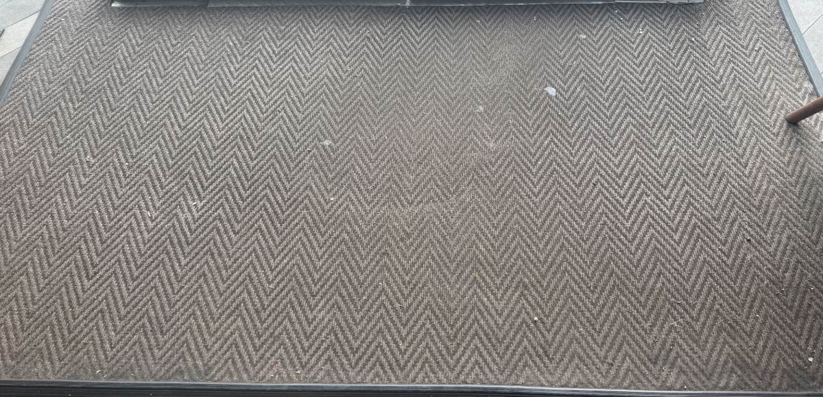 The same Borehamwood entrance matting before cleaning, flattened and grey with trodden-in grit
