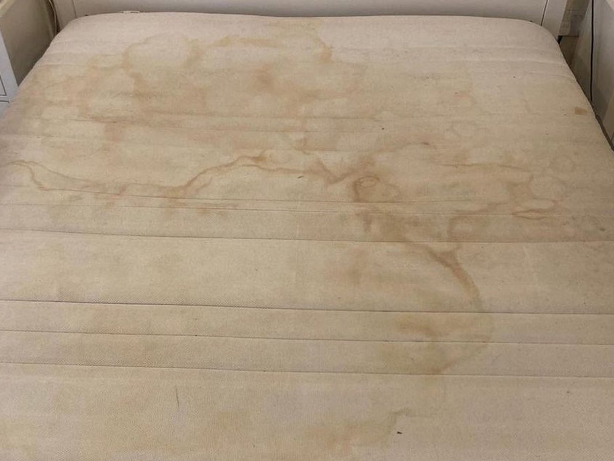 The same mattress before cleaning — stained and tired