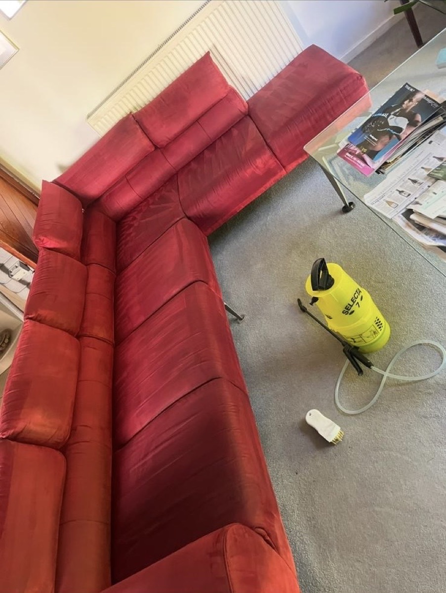 The same red sofa after cleaning — colour lifted and refreshed
