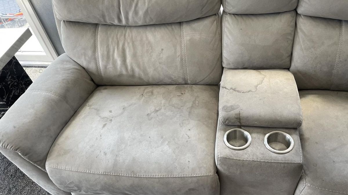 A grey recliner sofa before cleaning