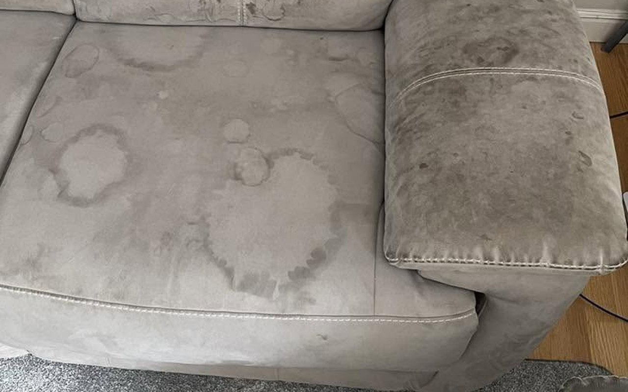 A grey fabric sofa with drink rings and grime before cleaning by Jay's Cleaning