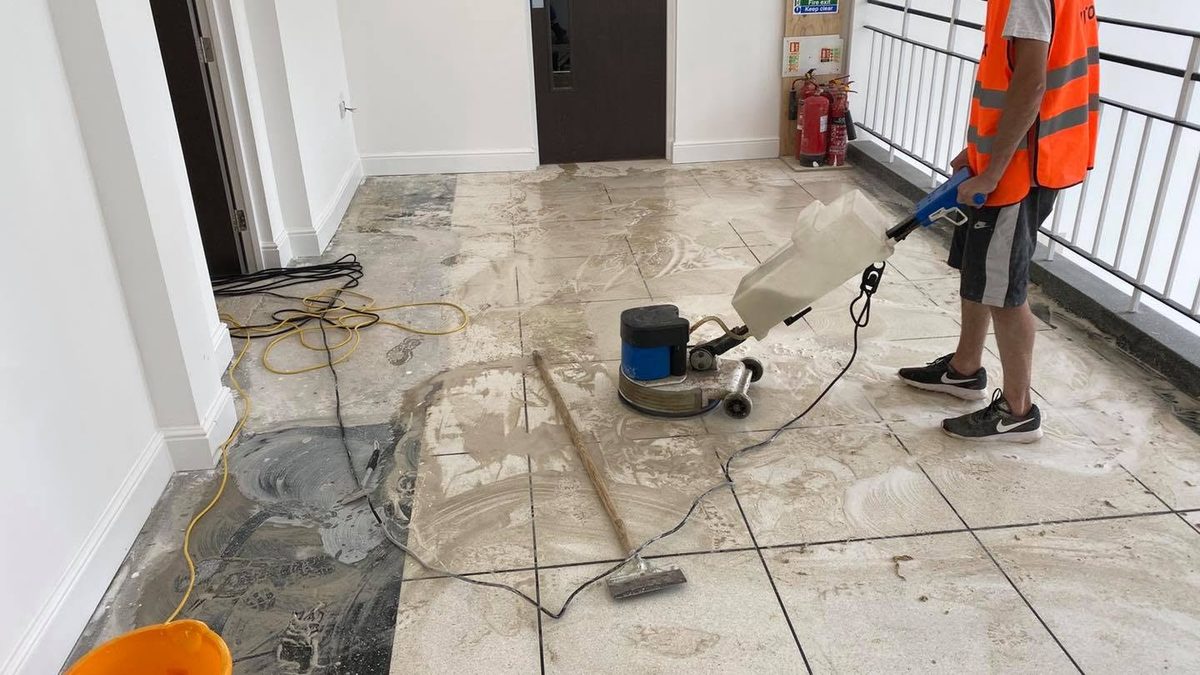 Machine-scrubbing a terrazzo landing during a stone restoration