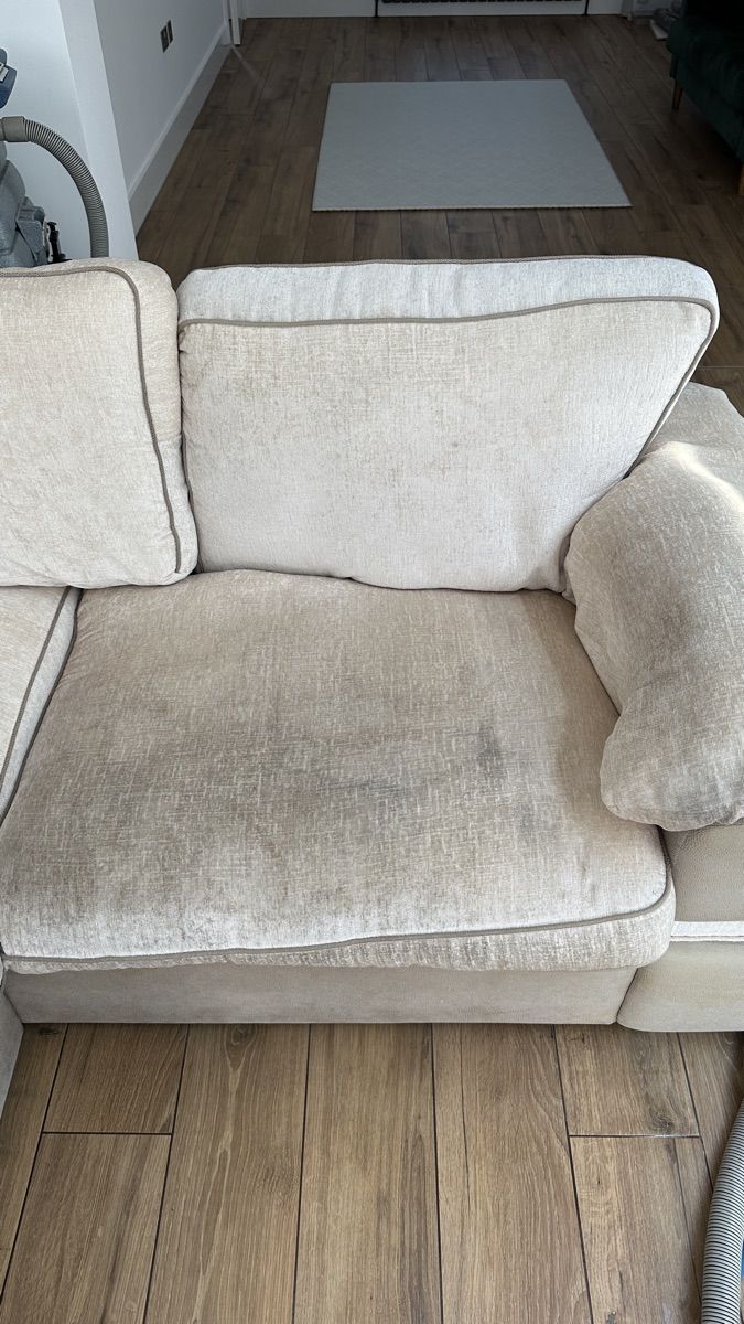The same cream sofa before cleaning — soiled and worn