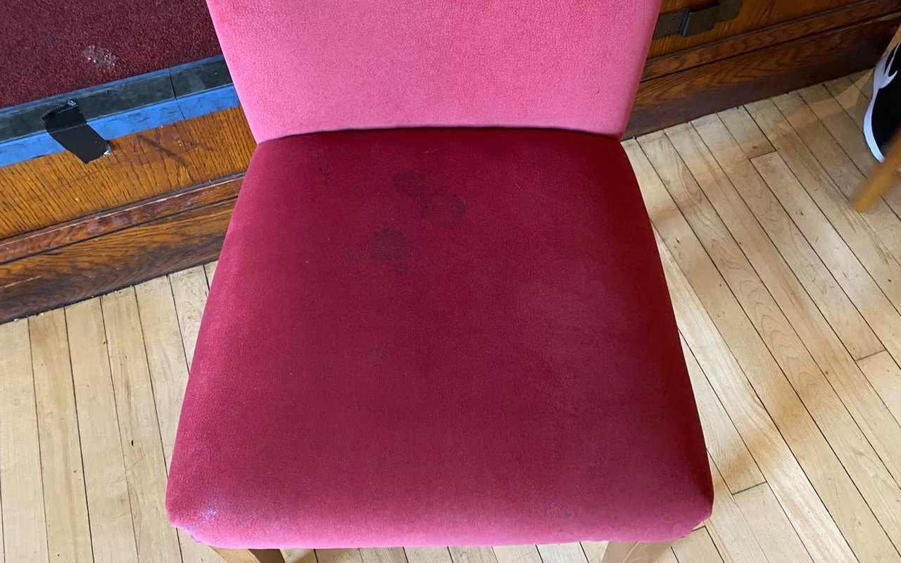 A pink velvet chair with dark stains before cleaning by Jay's Cleaning